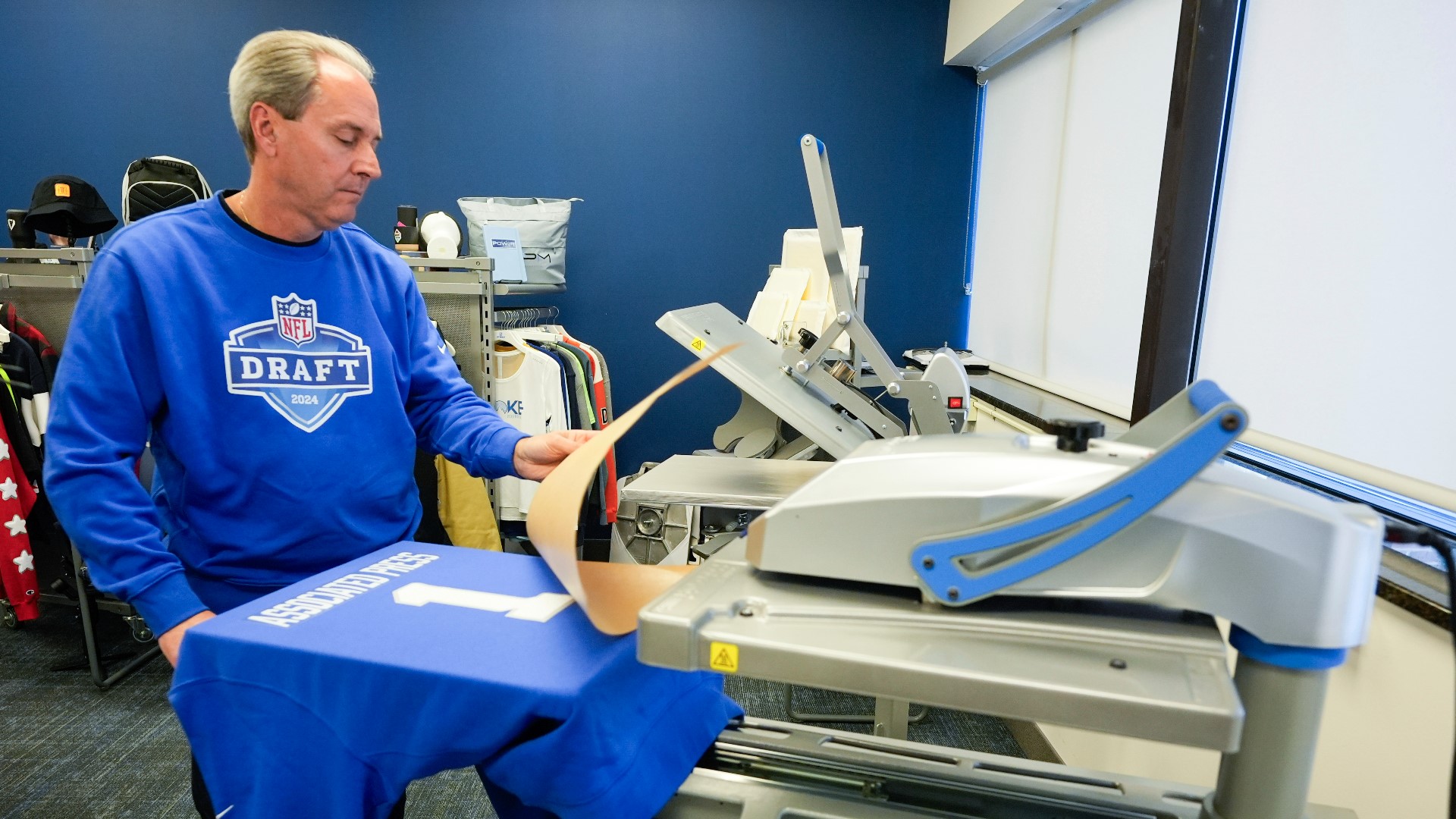 Brent Kisha, STAHLS' vice president of strategic sales, demonstrates using a Hotronix Fusion IQ heat press to put a name on shirt in St. Clair Shores, Mich.