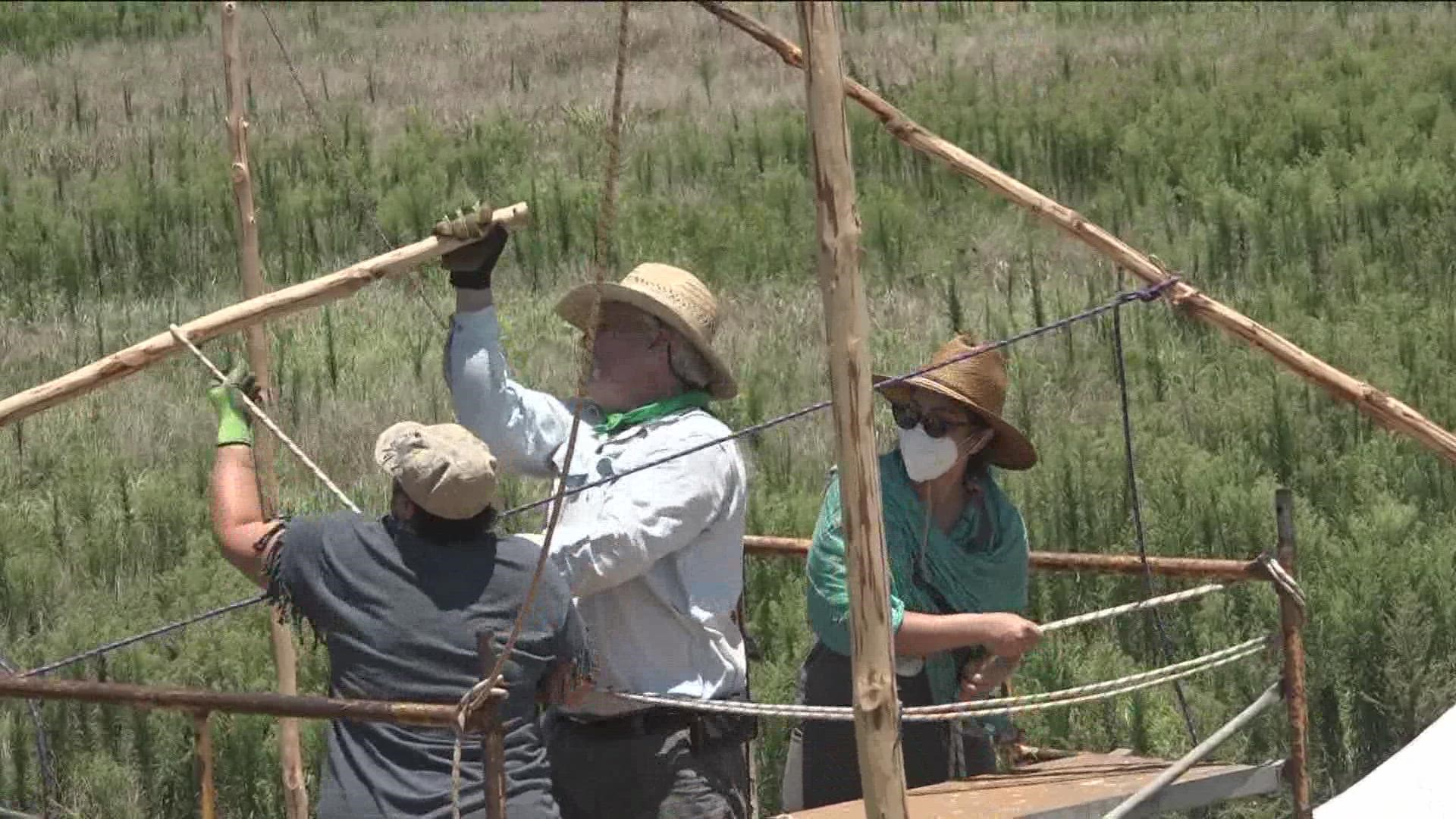 Volunteers are working together to reconstruct a Caddo tribe grass house replica at the Caddo Mounds State Historic Site