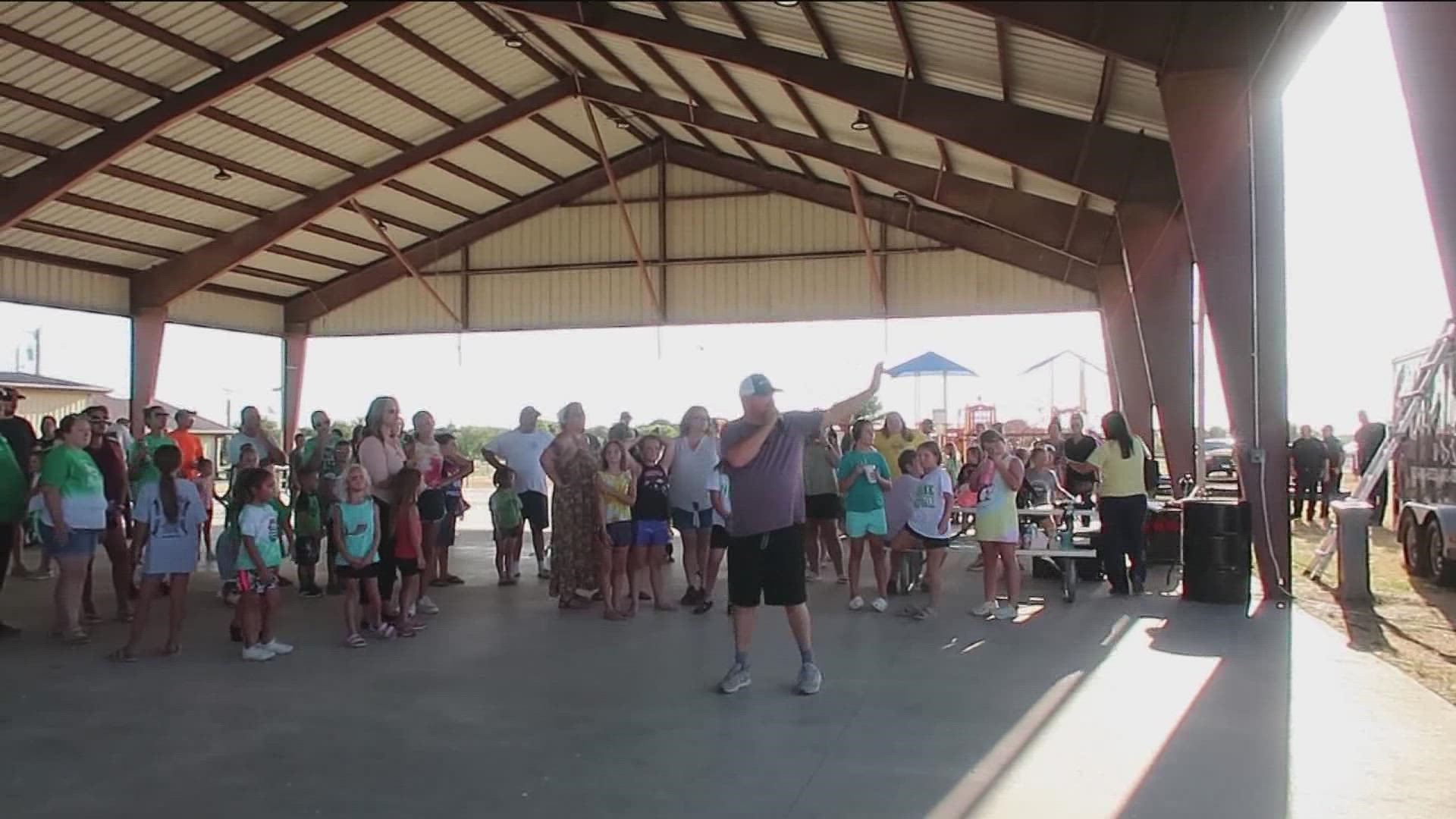 The 'Make It Rain' event drew about 100 local residents who danced under the water, wishing for rain in the future.