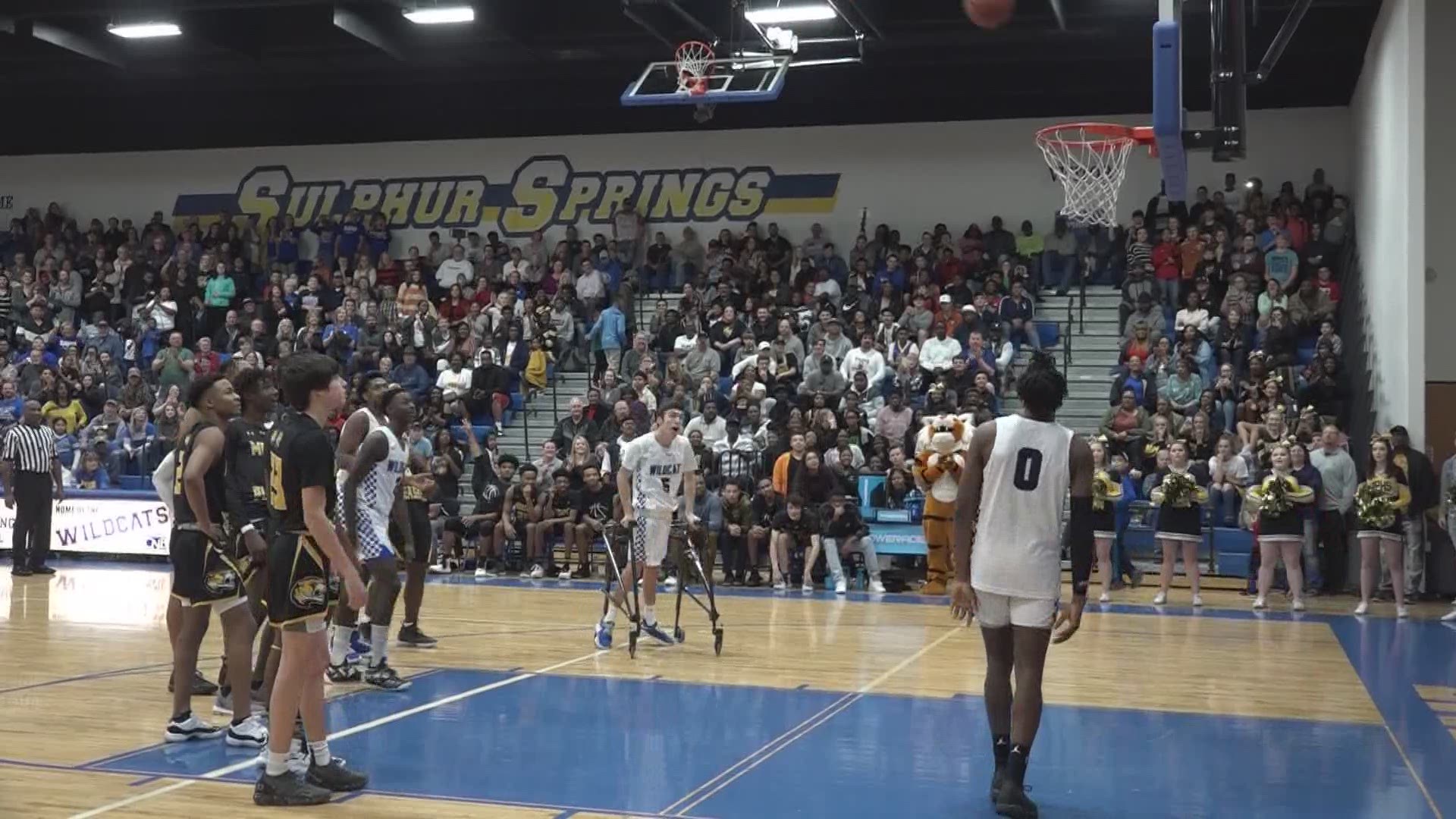 Basketball player with cerebral palsy scores opening basket of the night at Sulphur Springs High School.